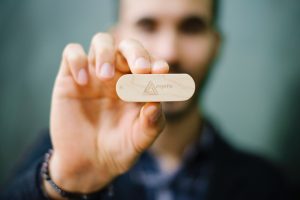 selective focus photography of man in holding wooden ornament